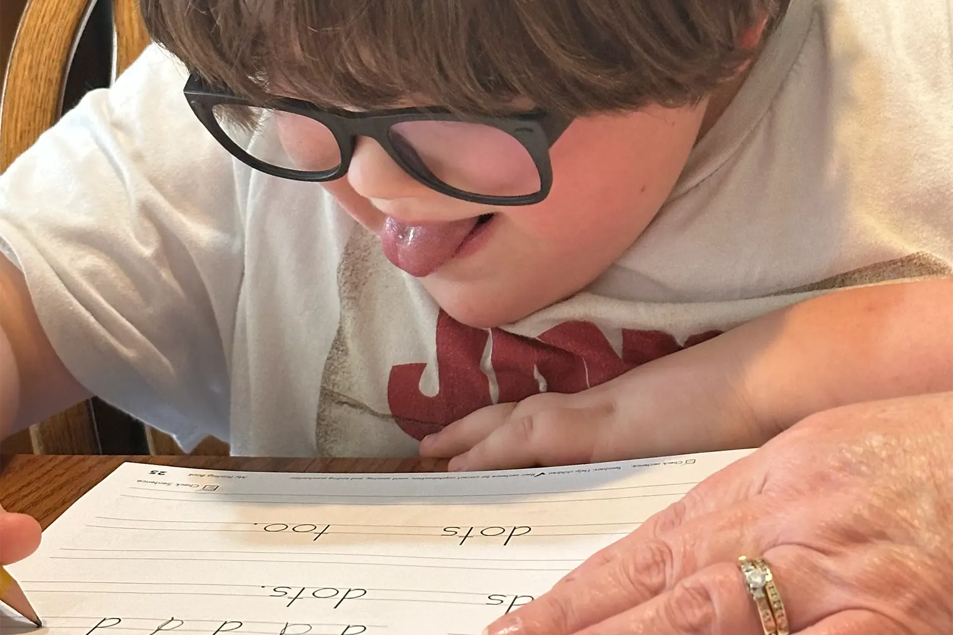 child with autism working on school work with his tutor