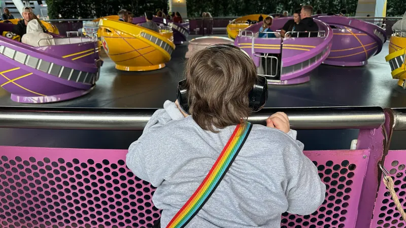 little boy with autism watching an amusement park ride