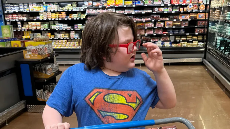 young autistic boy helping with grocery shopping